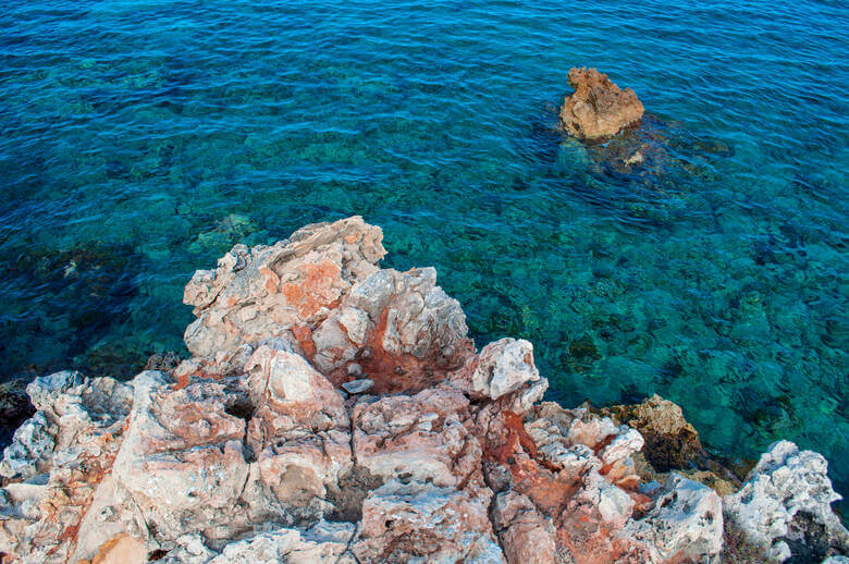 Blaues Wasser und Felsen auf der Insel Menorca in Son Bou
