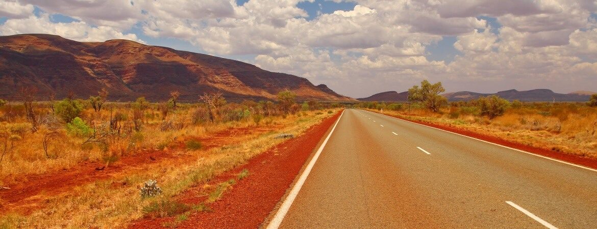 Straße an der australischen Westküste mit Bergen im Hintergrund