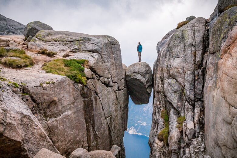 Mutiger Wanderer auf dem Kjeragbolten in Norwegen