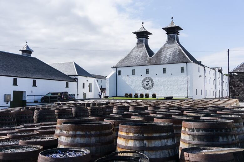Lagavulin-Destillerie in Schottland mit Weinfässern im Vordergrund