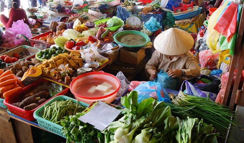 Händler verkauft frisches Gemüse auf einem Markt in Vietnam