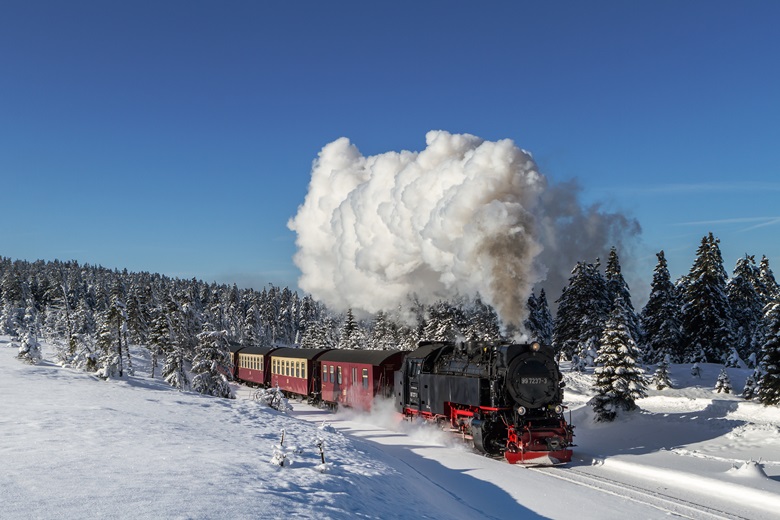 Harzer Schmalspurbahn fährt durch die schneebedeckte Harzregion