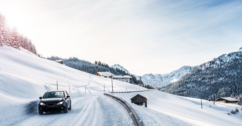 Auto fährt durch Schnee in den Bergen