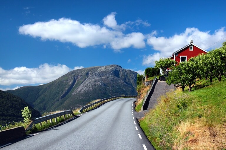 Straße mit Häuschen am Hardangerfjord in Norwegen