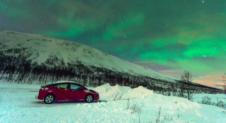 Auto unter den Polarlichtern in Norwegen