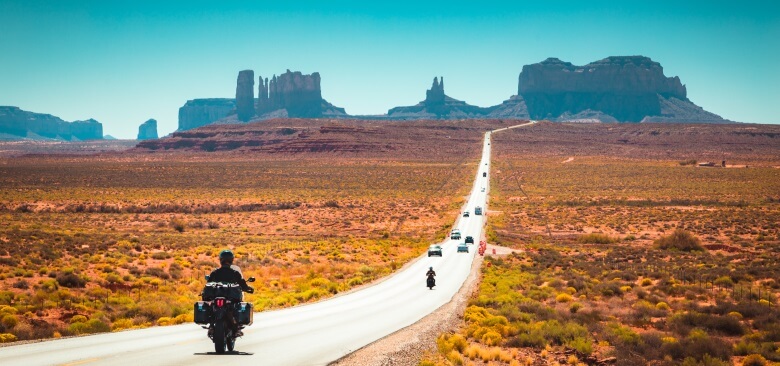 Motorradfahrer auf der Straße zu Monument Valley in den USA