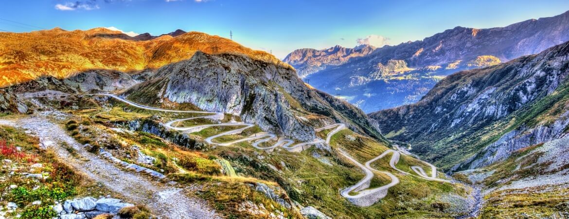 Blick über den kurvenreichen Gotthardpass in den Schweizer Alpen bei Sonnenuntergang