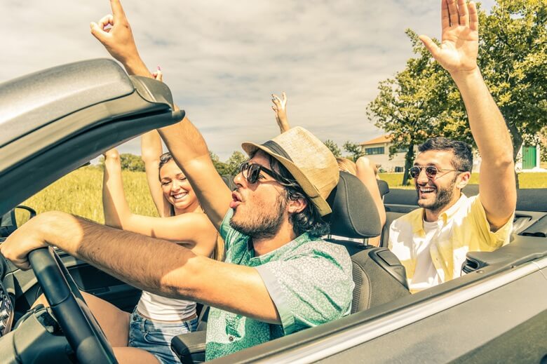 Freunde hören Roadtrip-Musik im Auto und haben Spaß