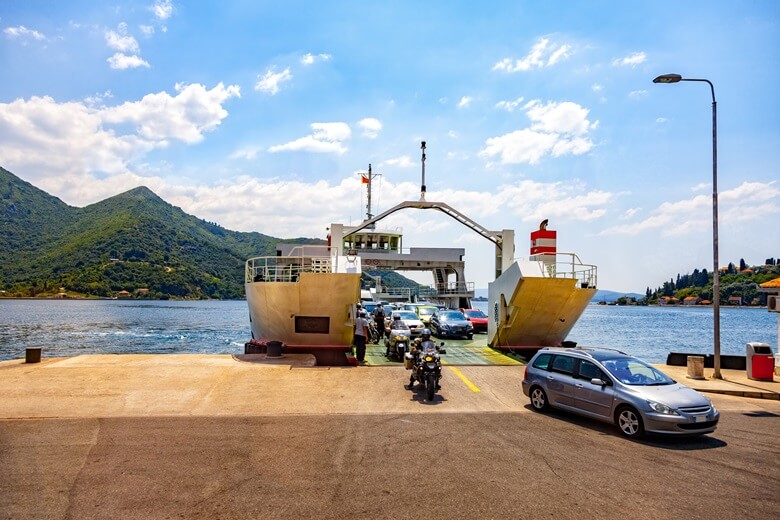 Autos verlassen die Fährte in der berühmten Kotor-Bucht in Montenegro