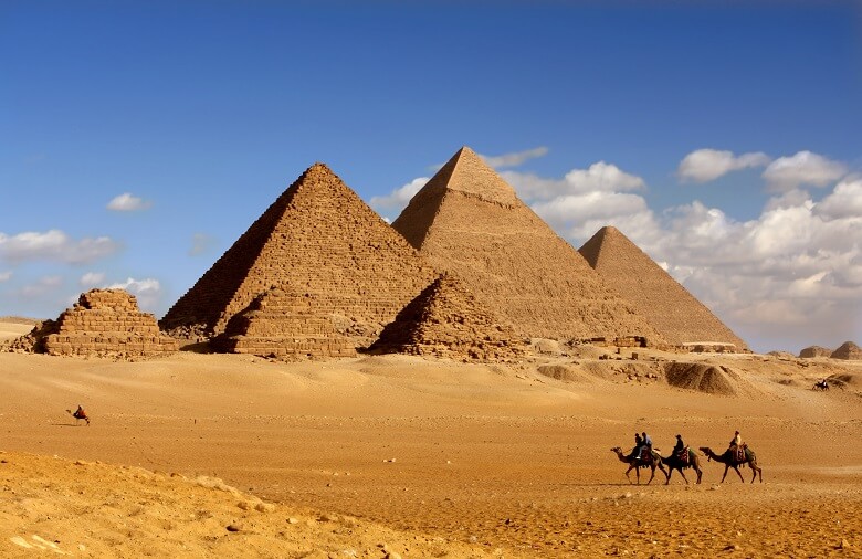 Kamele in der ägyptischen Wüste vor den Pyramiden von Gizeh