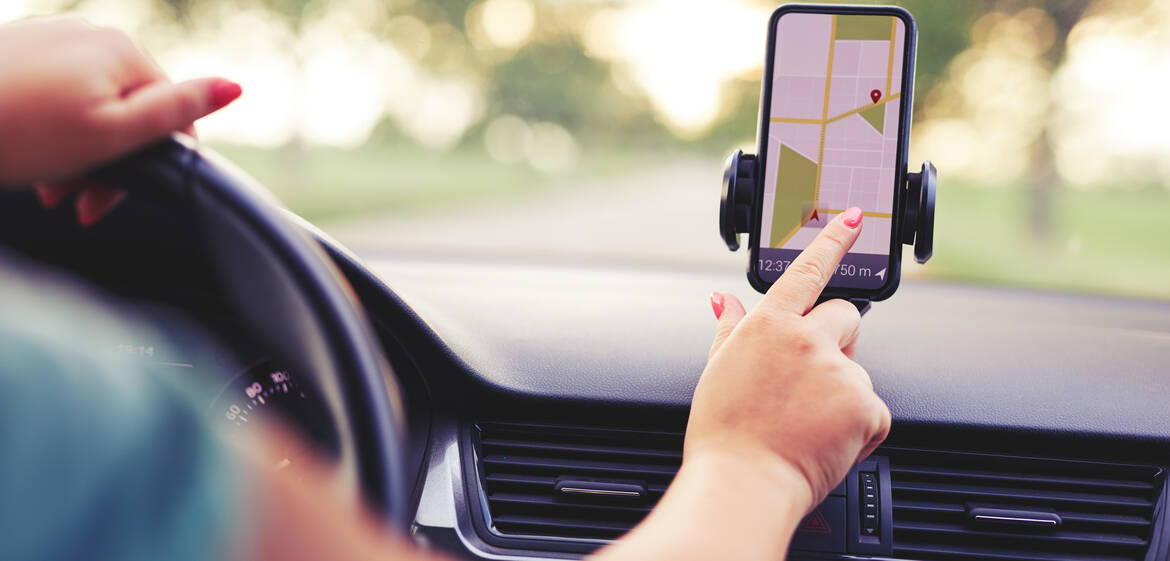 Frau bedient eine Navigations-App im Auto