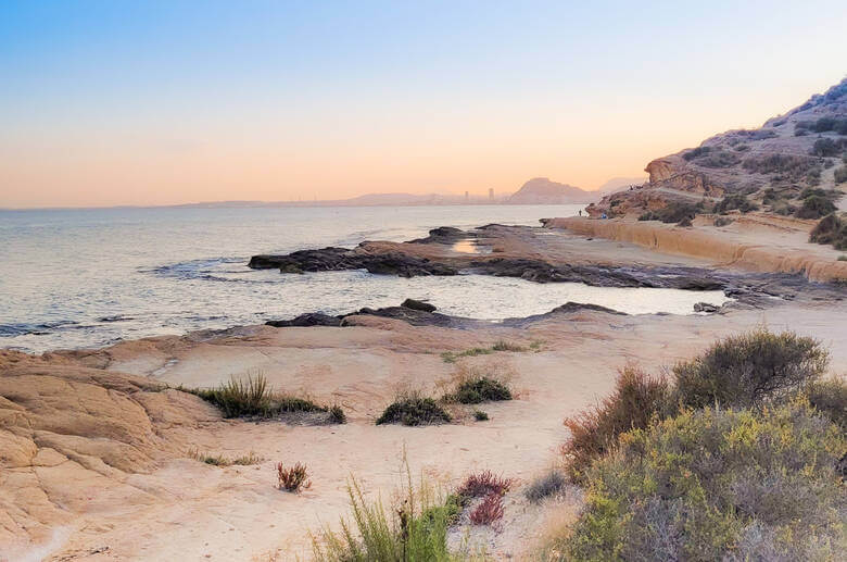 Sonnenuntergang an der Cala Cantalar mit Blick auf die Burg Santa Barbara, Alicante, Costa Blanca