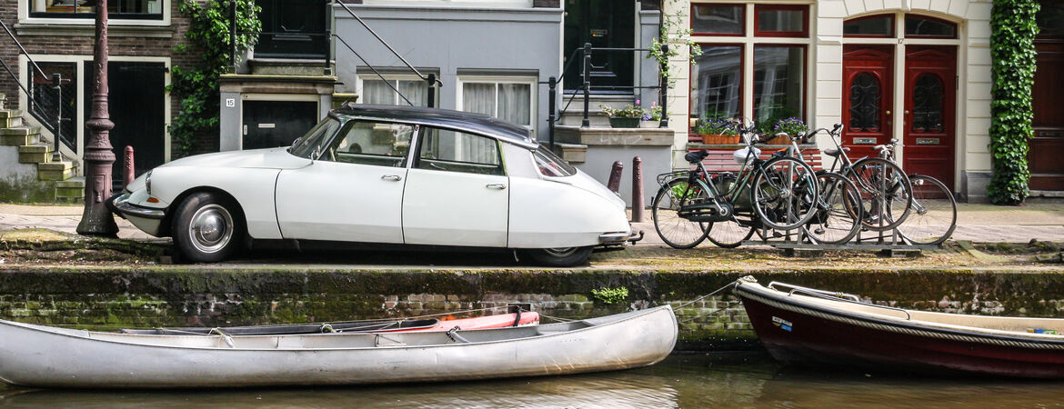 Oldtimer parkt an einer Gracht in Amsterdam