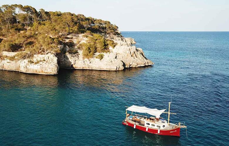 Boot auf dem Meer vor steiniger Küste auf Mallorca