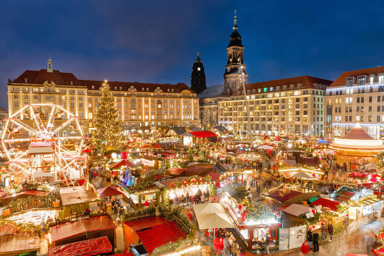 Der Striezelmarkt in Dresden mit geschmückten Hütten und Riesenrad