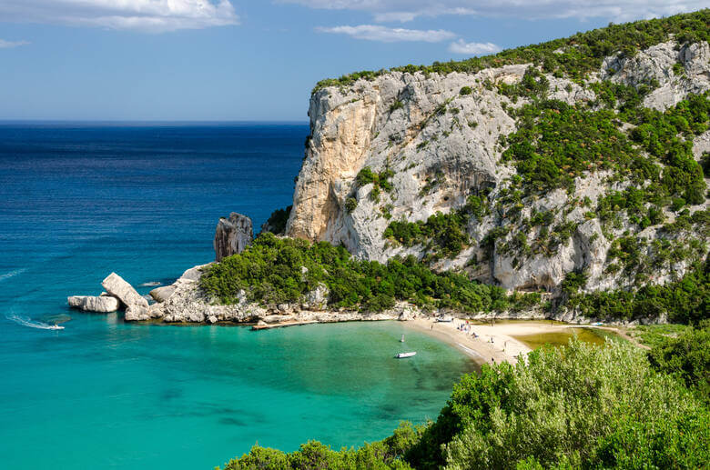 Die Bucht Cala Luna liegt hinter einer riesigen Klippe und blickt auf das türkisblaue Meer