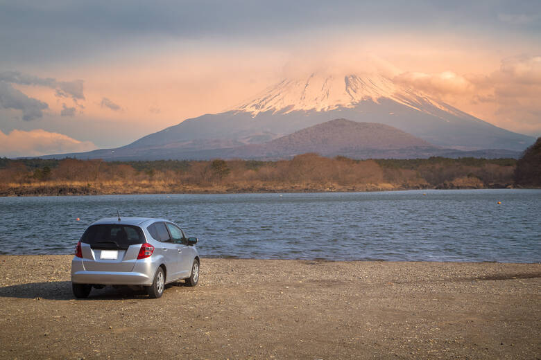 Auto steht am Ufer eines Sees mit Blick auf den Mount Fuji in Japan