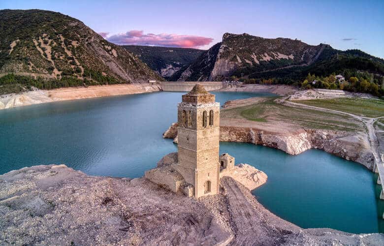 Der Stausee Embalse de Mediano im Sonnenuntergang. Im Vordergrund steht die einsame Kirche der versunkenen Ortes Mediano.