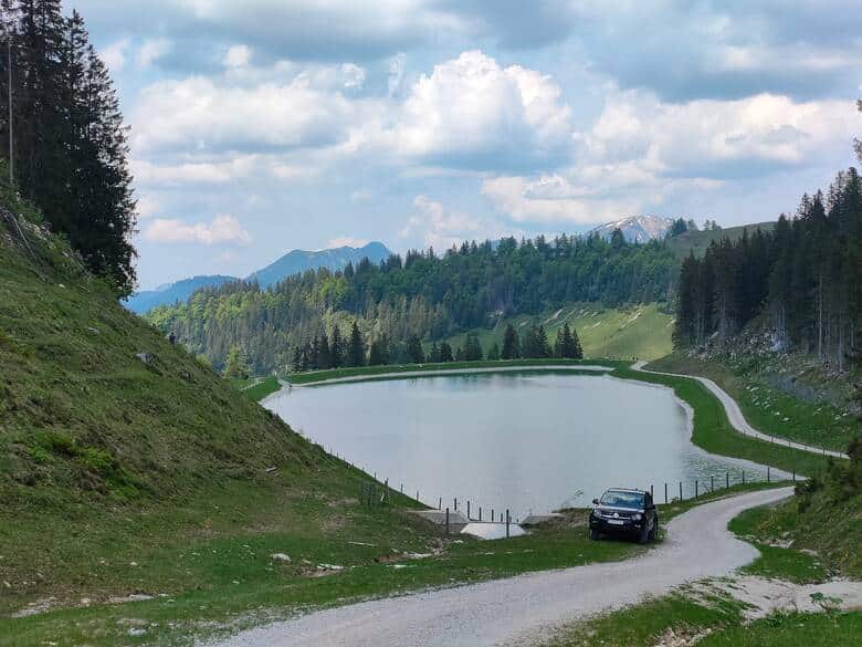 Auto steht an einem Bergsee in Österreich
