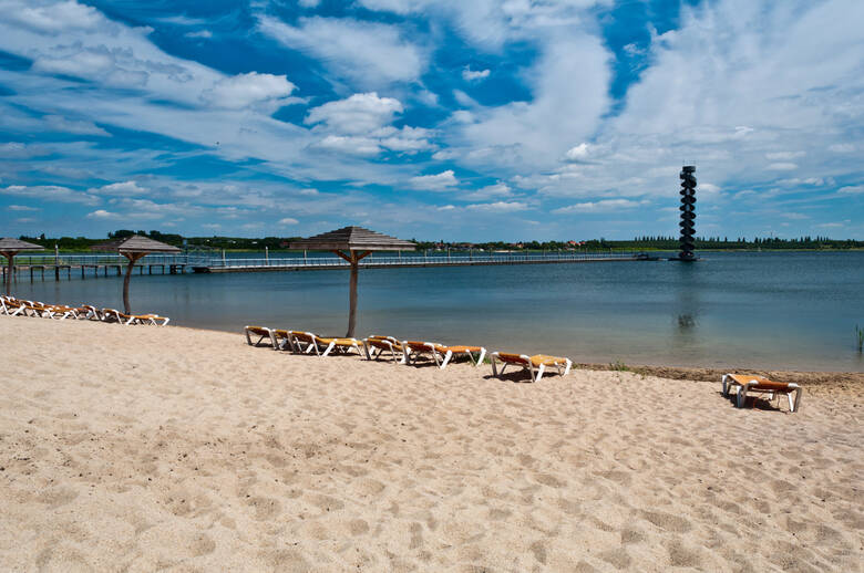 Sandstrand mit Liegen und Schirmen am Großen Goitzschesee