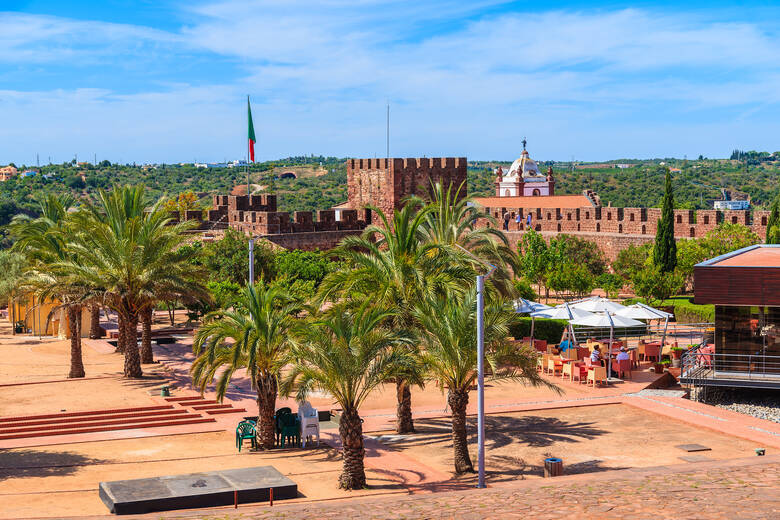 Blick auf die Burgmauern von Silves und Café an der Algarve