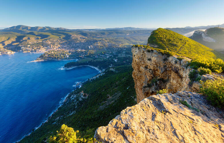 Cap Canaille, eine hohe Felswand zwischen Cassis und La Ciotat mit einem Ort im Hintergrund