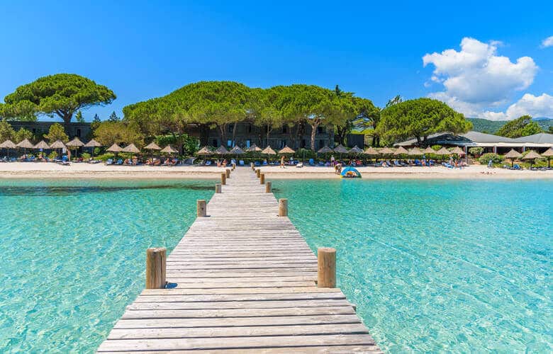 Blick auf den Strand Santa Giulia vom Wasser aus mit einem langen Steg