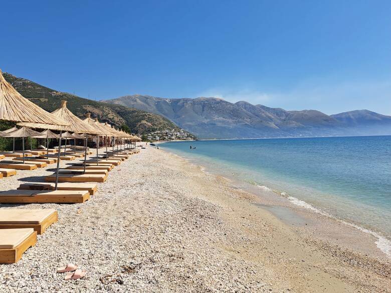 Strandliegen und Schhirme an einem Strand in Albanien