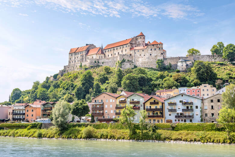 Burg zu Burghausen thront über bunten Häusern in Bayern